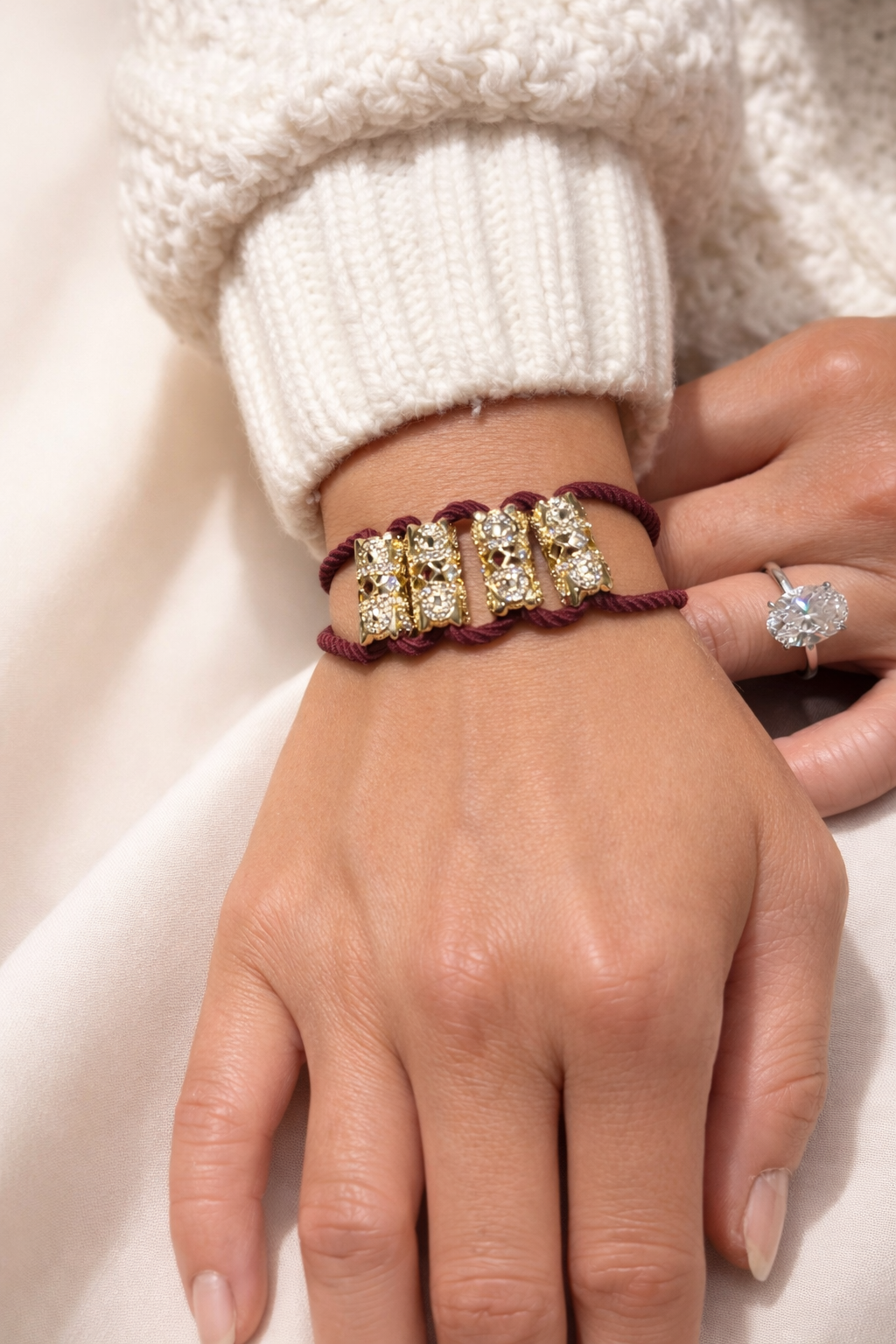 Close-up of jeweled hair tie CZ burgundy cord worn as bracelet